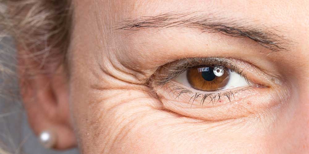 Closeup of older womans eye with wrinkles.